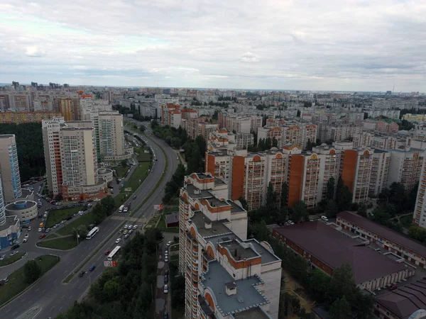 Widok z lotu ptaka na rosnące miasto w pochmurne dni. Drone widok nowego kompleksu budynków w centrum miasta z domów i dróg pod zachmurzonym niebem — Zdjęcie stockowe