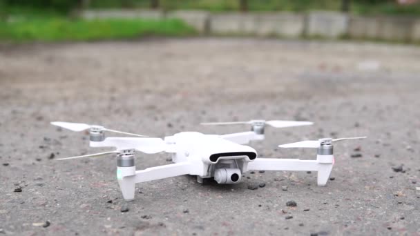 Quadcopter vertrekt op straat, close-up. De witte drone — Stockvideo