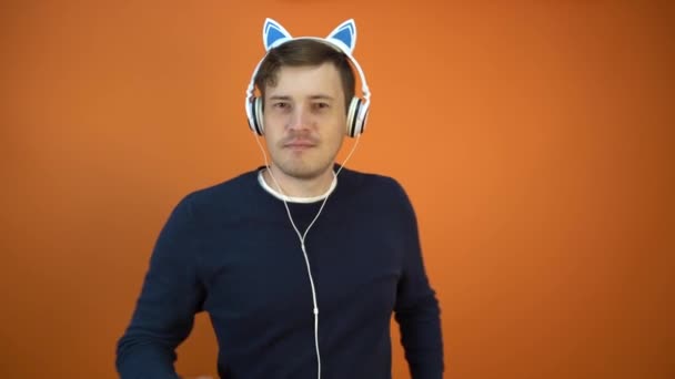 Young Man Headphones Ears Dancing Orange Background — Stock Video
