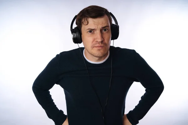 Hermoso hombre joven en los auriculares está bailando aislado en el fondo blanco. El concepto del Día Internacional de la Música. — Foto de Stock