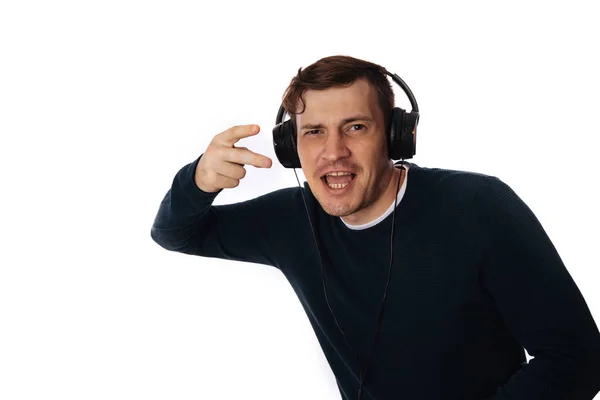 Hermoso hombre joven en los auriculares está bailando aislado en el fondo blanco. El concepto del Día Internacional de la Música. — Foto de Stock