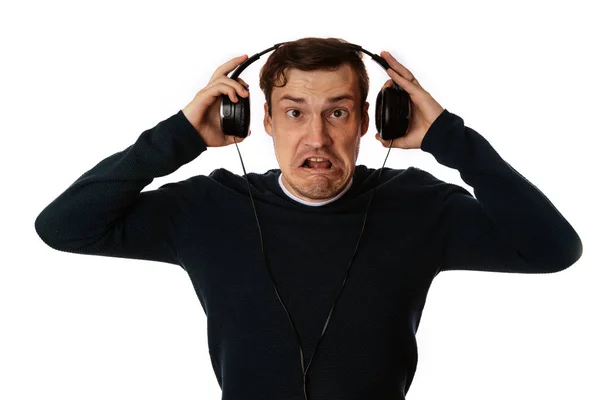 Hermoso hombre joven en los auriculares está bailando aislado en el fondo blanco. El concepto del Día Internacional de la Música. — Foto de Stock