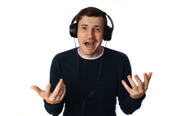 Hermoso hombre joven en los auriculares está bailando aislado en el fondo blanco. El concepto del Día Internacional de la Música. — Foto de Stock