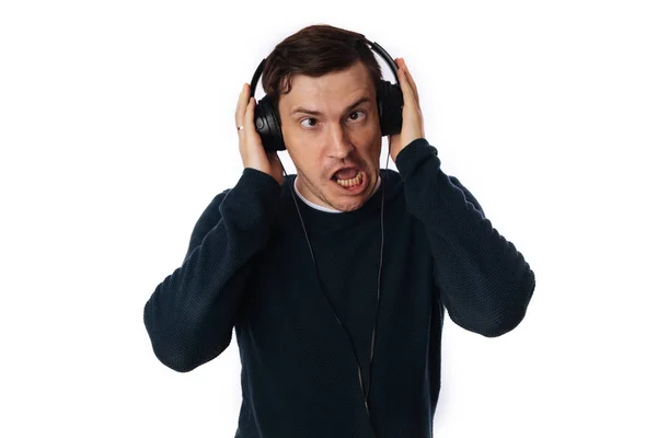 Hermoso hombre joven en los auriculares está bailando aislado en el fondo blanco. El concepto del Día Internacional de la Música. — Foto de Stock