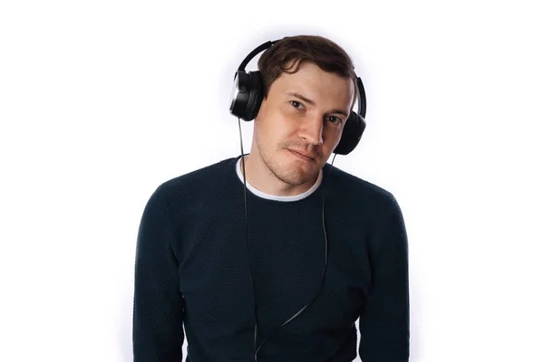 Hermoso hombre joven en los auriculares está bailando aislado en el fondo blanco. El concepto del Día Internacional de la Música. — Foto de Stock