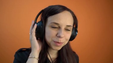 Kulaklıklı genç ve güzel bir kadın müzik dinliyor. 
