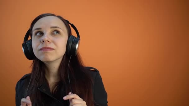 音楽とダンスを聴くヘッドフォンの美しい若い女性 — ストック動画