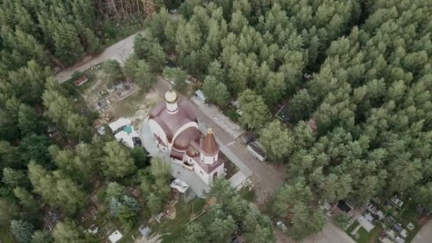 Paisagem bonita de igreja velha na floresta. Vista aérea da bela paisagem da antiga igreja tradicional com cúpulas e cruzes rodeadas de árvores verdes — Vídeo de Stock