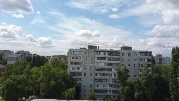 Vista aérea de la ciudad en crecimiento a la luz del sol. Drone vista del nuevo complejo de edificios en el centro de la ciudad con casas y carreteras bajo el cielo nublado — Vídeos de Stock