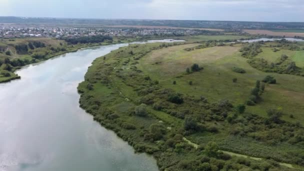 Estanque tranquilo en el campo verde. Desde arriba increíble lago con aguas tranquilas situado cerca de bosque verde en la naturaleza — Vídeo de stock