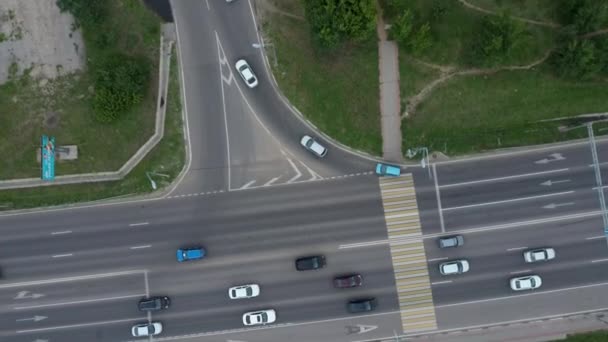 Автомобили движутся по дороге в городе, двухстороннее движение. Вид с воздуха на автомобили, движущиеся по дороге летом . — стоковое видео