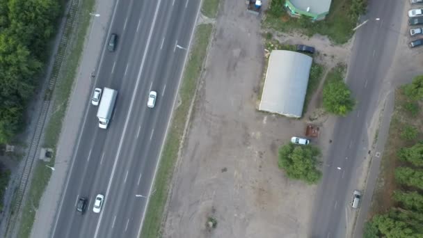 Şehirdeki iki yönlü trafikte arabalar yolda ilerliyor. Yazın yola çıkan arabaların hava manzarası.. — Stok video