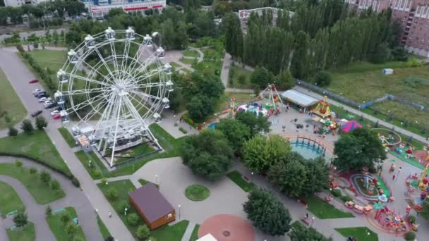 Vue aérienne du parc. La grande roue est dans le parc. Le parc est un espace paysager créé pour les loisirs. C'est un lieu de passe-temps agréable pour les gens . — Video