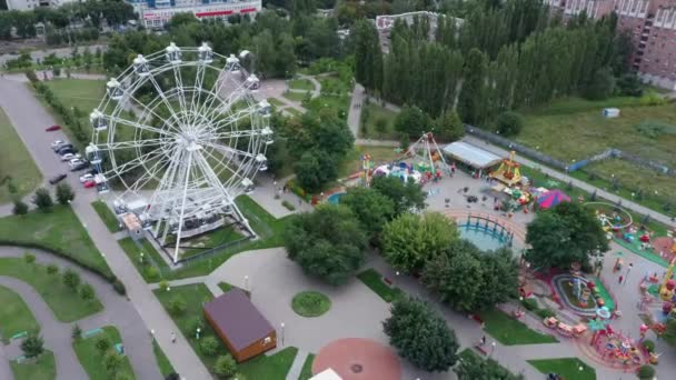 Widok z lotu ptaka. Diabelski młyn jest w parku. Park jest terenem krajobrazowym stworzonym do rekreacji. To miejsce przyjemnej rozrywki dla ludzi.. — Wideo stockowe