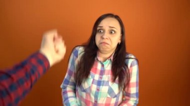 Bir adam bir kadını yumruğuyla tehdit eder. Suratının önünde bir adam yumruğu. Kişiler arası çatışmalar ve aile içi şiddet.