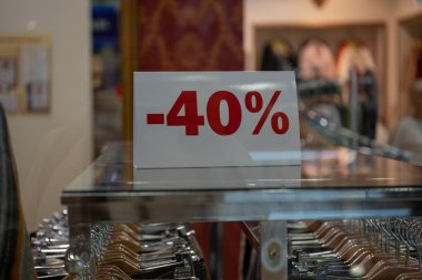 Sezon satış, black friday ve alışveriş konsepti. Dükkandaki stantlarda satış tabelaları. Vitrinlerde standda satış işareti yüzde 40 indirim fiyatı.