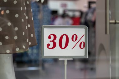 Sezon satış, black friday ve alışveriş konsepti. Dükkandaki stantlarda satış tabelaları. Vitrinlerde standda satış işareti yüzde 30 indirim fiyatı.