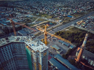 Vinç ile yapım aşamasında modern bina. Akşam yüksek vinç ile bina inşa havadan görünümü