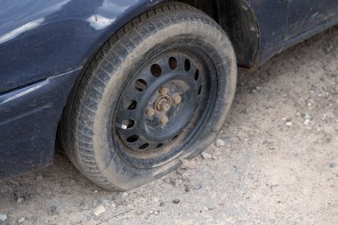 Sokakta sönmüş tekerleği olan araba. Sokakta park etmiş sönmüş tekerleği olan eski araba