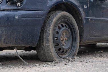 Sokakta sönmüş tekerleği olan araba. Sokakta park etmiş sönmüş tekerleği olan eski araba