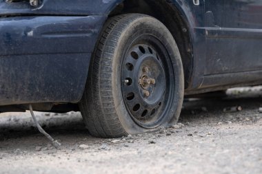 Sokakta sönmüş tekerleği olan araba. Sokakta park etmiş sönmüş tekerleği olan eski araba
