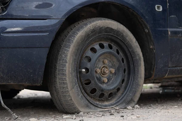 Car with deflated wheel on street. Old car with deflated wheel parked on street — Stock Photo, Image
