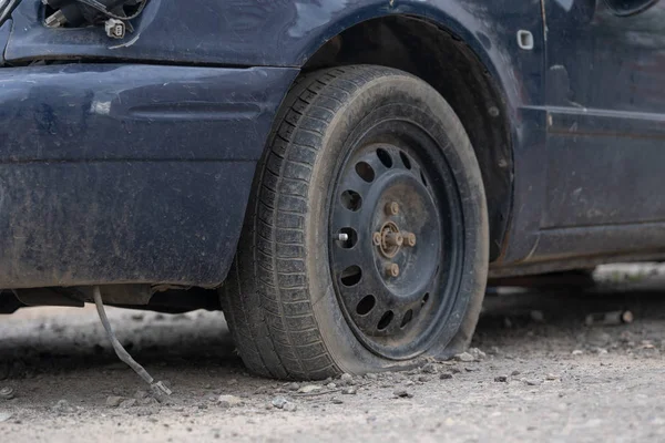 Auto s vykastrované kolečko na ulici. Staré auto s vyprázdním kolečkem zaparkované na ulici — Stock fotografie