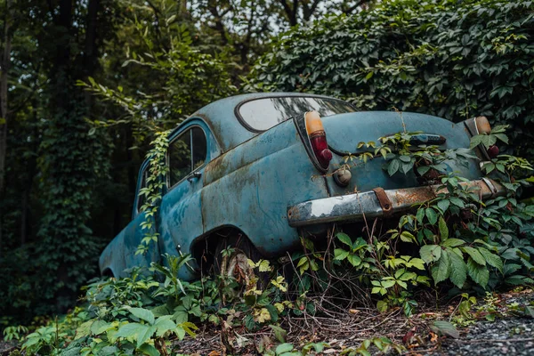 Un coche oxidado abandonado en el depósito de chatarra. Olvidado desechado oxidado viejo coche azul en el desguace — Foto de Stock