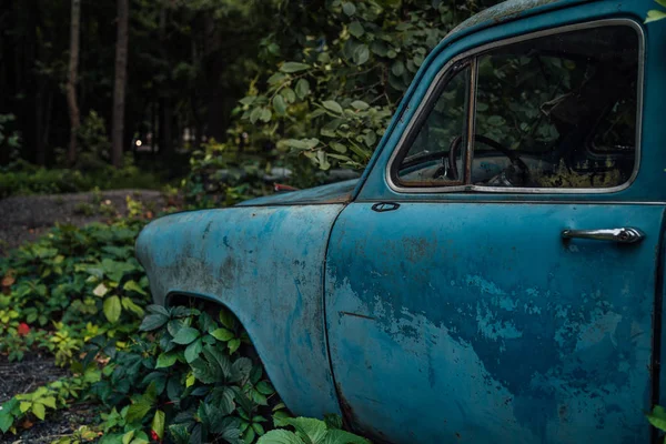 Abandoned rusty car in junkyard. Forgotten discarded rusty old blue car in scrapyard — Stock Photo, Image