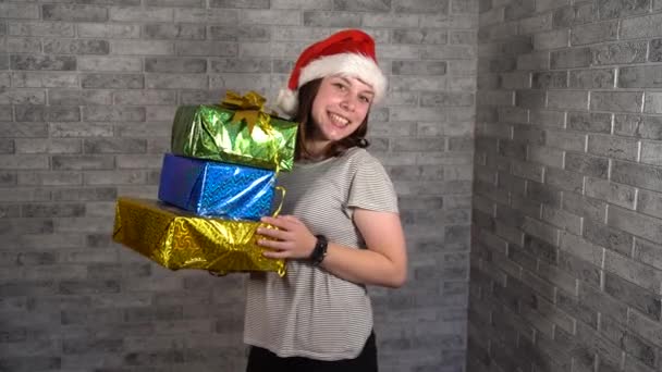 Smiling Brunette Female Wearing New Year Hat Wrapped Presents Background — Stock Video