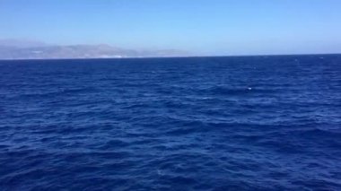 Güneşli bir günde güzel bir deniz manzarası sakin sularda rüzgar desenleri ve bulutsuz açık mavi gökyüzü. Ufuk çizgisi olan okyanus görünümü, metin için bir sürü kopya alanı olan arkaplan.