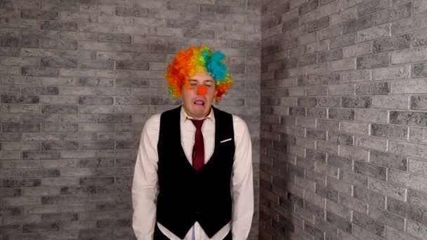 Een man geeuwt op het werk. Kantoormedewerker in pruik, clown concept op het werk. Zakenman met een pruik. Originele clown kostuum voor Halloween — Stockvideo