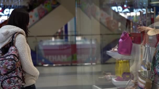 Una mujer mira en una ventana de la tienda en el Mall. Concepto: comprar — Vídeo de stock