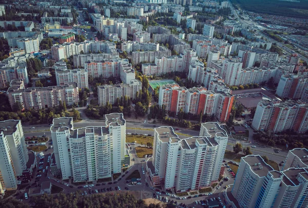 Flygfoto över växande stad. Drönare syn på nya byggnadskomplex i centrum med hus — Stockfoto