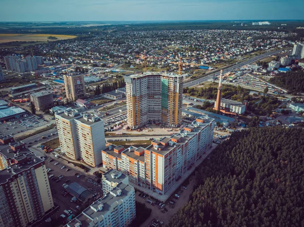 Modern konut binalarının havadan görünüşü. Yüksek katlı binaların dış cephesi. Ağaçlarla çevrili konut binası. Orman çevresindeki gökdelenler