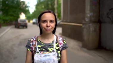 Sırt çantasıyla şehirde yürüyen genç bir kadın.