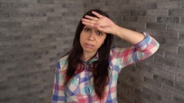 Ekose gömlekli güzel duygusal bir kadın kulağının dibinde el ele tutuşuyor ve gri tuğladan bir arka plandaki konuşmaya kulak misafiri olmaya çalışıyor. Meraklı bir esmer geniş bir şekilde gülümsüyor ve birini gözetliyor. Şey...