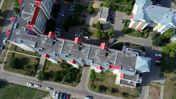 Vue aérienne de la ville en pleine croissance en plein soleil. Vue par drone du nouveau complexe de construction dans le centre-ville avec des maisons et des routes sous un ciel nuageux — Video