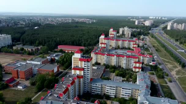 Luftaufnahme der wachsenden Stadt im Sonnenlicht. Drohnenblick auf neuen Gebäudekomplex in der Innenstadt mit Häusern und Straßen unter bewölktem Himmel — Stockvideo