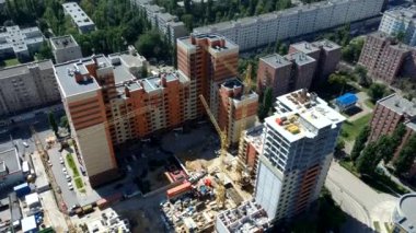 İnşaat alanında altyapısı gelişen yeni bir yerleşim yeri. Ev yapım aşamasında. Modern şehir binası vinçle inşa ediliyor.