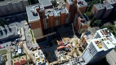 İnşaat alanında altyapısı gelişen yeni bir yerleşim yeri. Ev yapım aşamasında. Modern şehir binası vinçle inşa ediliyor.