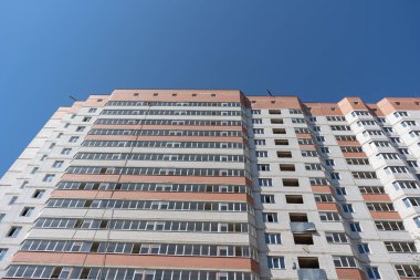 Mavi gökyüzü olan güneşli bir günde modern apartman binaları. Modern bir apartmanın ön cephesi. Modern apartman binası mimarisi
