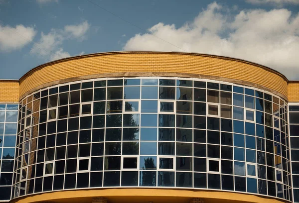 Modern ofis binasının pencereleri. Modern mimari bankası finans kulesi binası. Bulutlar ve parlak mavi gökyüzü modern bir ticaret binasının kare aynalı pencerelerine yansıyor.