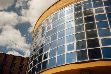 Modern ofis binasının pencereleri. Modern mimari bankası finans kulesi binası. Bulutlar ve parlak mavi gökyüzü modern bir ticaret binasının kare aynalı pencerelerine yansıyor.