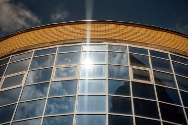 Modern ofis binasının pencereleri. Modern mimari bankası finans kulesi binası. Bulutlar ve parlak mavi gökyüzü modern bir ticaret binasının kare aynalı pencerelerine yansıyor.