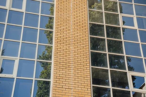 Вікна сучасної офісної будівлі. Сучасна архітектура - будівля банківського фінансового офісу. хмари і яскраво-блакитне небо, відображене на площі, відображає вікна сучасної комерційної офісної будівлі — стокове фото