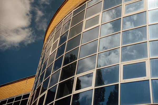 Окна современного офисного здания. Современная архитектура здания финансового офиса банка. облака и ярко-голубое небо, отраженные в зеркальных окнах современного торгового офисного здания — стоковое фото