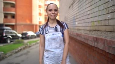 Günlük giysiler içindeki güzel duygusal bir kadın mutlu bir şekilde güler ve baş parmağını kaldırır. Bir kadın sokakta bir onay jesti gösteriyor. Sevmek ya da sevmemek kavramı.