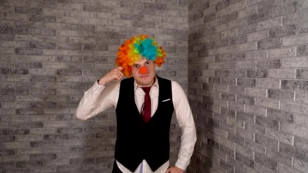 Un homme se caresse le nez au travail. Travailleur de bureau en wig clown, concept de clown au travail. Homme d'affaires avec perruque clown. Costume de clown original pour l'Halloween — Video