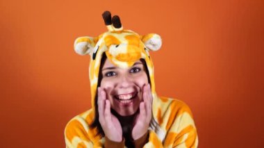 Zürafa şeklinde pijama. Turuncu arka planda bir kadının duygusal portresi. Takım elbiseli çılgın ve komik bir adam. Çocuk partileri için animatör. Cadılar Bayramı partisi kostümü